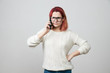 Redhead woman model in glasses and white sweater complaining while talking on smartphone, confused and puzzled expression, frowning, being displeased. Girl retells situation to her friend. 