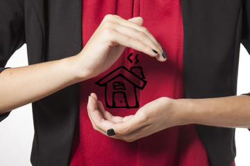 woman holds a drawing of a house in her hands