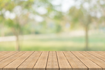 Wall Mural - Empty wood table top on nature green blurred background at garden,space for montage show products