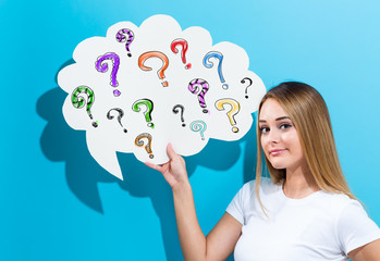 Wall Mural - Question marks with young woman holding a speech bubble