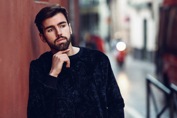 Young bearded man, model of fashion, in urban background wearing casual clothes.