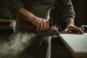 Wall Mural - carpenter works with manual and electric equipment