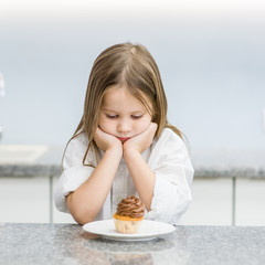 sad girl looking at cupcake