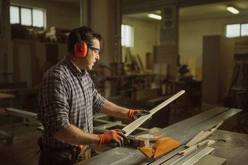 Wall Mural - carpenter works with manual and electric equipment