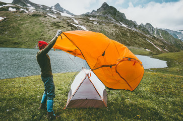 man pitching tent camping outdoor travel adventure lifestyle concept mountains journey vacations int