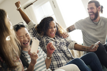 Group of diverse friends playing game on mobile phone