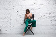 Topless brunette woman sitting on a directors chair