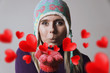 © grufnar - beautiful blonde woman wearing winter clothing blowing heart kisses