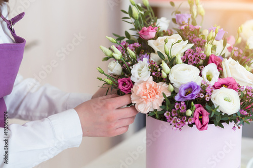 Fotomural Woman florist making a beautiful flower composition in a flower shop