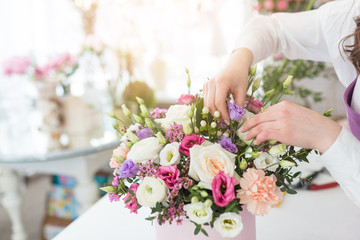 Woman florist making a beautiful flower composition in a flower shop