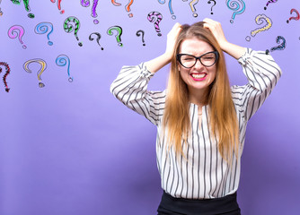 Wall Mural - Question Marks with young business woman feeling stressed