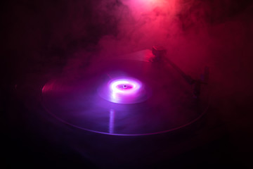 Turntable vinyl record player. Retro audio equipment for disc jockey. Sound technology for DJ to mix & play music. Vinyl record being played against burning fire background