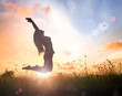 World environment day concept: Silhouette of happy woman jumping with her hands raised at autumn sunset background
