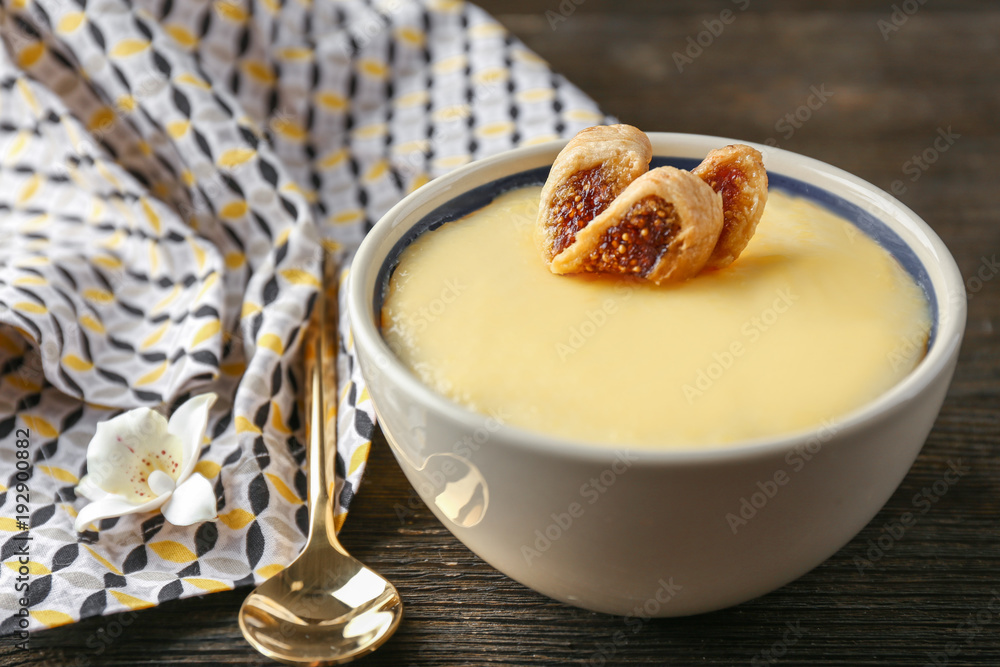 Bowl with tasty vanilla pudding on table