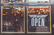 Open vintage sign broad through the glass of store window. Asia.