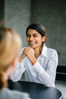 © Danon - A portrait in an interview session of a young and attractive and and and and and Indian Asian woman. She looks very competent in a white shirt, as she sits and talks to her interviewees.