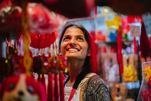 A Portrait Of A Young Indian Lady Wandering During The Chinese New Year Festival In Asia At Night On The Market. When She Looks Around The Trinkets Hanging For The Festivity, She Looks Fascinated.