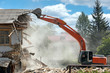 industrial excavator working at the demolition of an old residential building