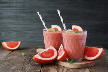Wall Mural - Grapefruit smoothies with banana on a wooden table