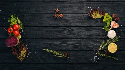  The background of cooking. A set of spices and fresh vegetables. Top view. Free space for your text. On a wooden background.