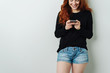 © contrastwerkstatt - Pretty smiling young woman reading an sms