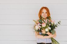 Close Up Portrait Of Adorable Red Hair Kid Girl Holding Big Flower Bouquet With Roses