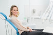 © LIGHTFIELD STUDIOS - Smiling woman at check-up in modern dental clinic