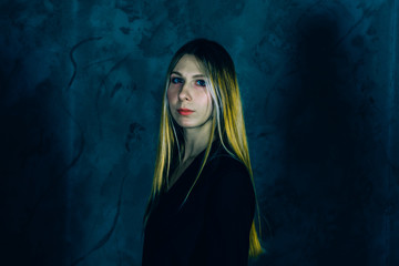 Attractive pretty young model posing against a dark studio background with copy space looking. Atomic blonde woman. Comic style of color