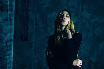 Attractive pretty young model posing against a dark studio background with copy space looking. Atomic blonde woman. Comic style of color