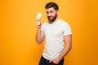 Portrait of a smiling bearded man showing credit card