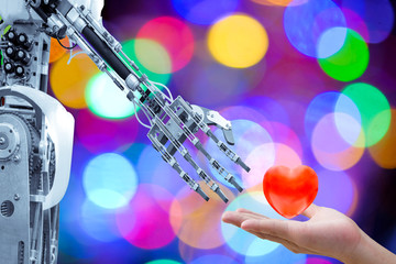 Human heart on hand send to an artificial robot in Valentine day for make the robots have love like a human, on multicolored bokeh blurred background