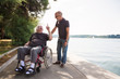 Senior In Wheelchair Spending Time Outdoors With His Nurse