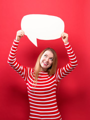 Wall Mural - Young woman holding a speech bubble on a red background