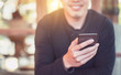 © oatawa - Happy male using smartphone at modern coffee shop, he chatting Online Messaging on mobile smartphone.