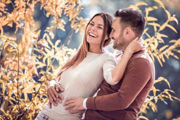 Wall Mural - Smiling couple hugging in nature.