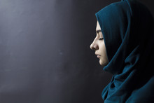 A Muslim Woman With Closed Eyes, On A Black Background. Arab Girl In Hijab In Profile.