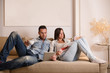 © Manuel Ruiz Martinez/ADDICTIVE STOCK - Couple using digital tablet and reading magazine while sitting on sofa