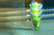 Piękny kielich z zieloną palącą się świecą na stole w restauracji.