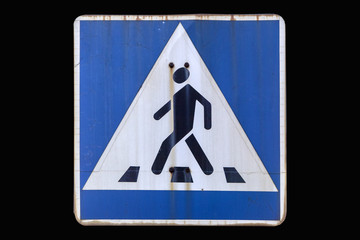 Old road sign 'Pedestrian crossing' isolated on black.