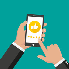 Website rating feedback and review concept. Hand holding and pointing to a smartphone with 5 star rating