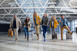 Full length portrait of group of tourist chasing each other at the airport. Their faces are joyous