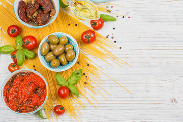 Wall Mural - Ingredients for preparation pasta spaghetti - tomato, olive oil, spices, herbs, green olives, tomato sauce