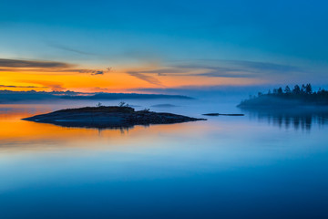 fog over lake. sunrise in the fog. wild nature of finland. islands of stone. mirror reflection in wa