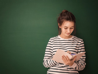 Canvas Print - Cute teenager girl with notebook on green background