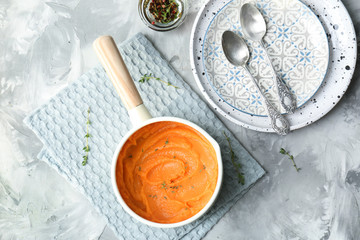 Canvas Print - Saucepan with tasty mashed sweet potato on table