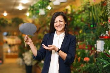 Wall Mural - Portrait of young woman with sign in greenhouse. Small business owner