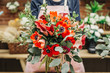 canvas print picture - Anonymous worker of floral shop holding amazing creative bouquet in hands. 