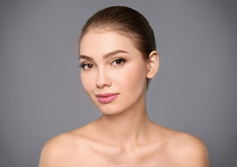 Poster - Portrait of beautiful young woman with clear skin on grey background