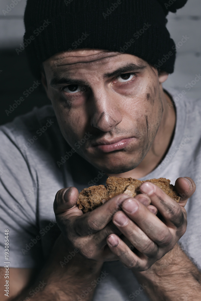 Homeless poor man with piece of bread