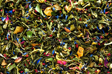 Wall Mural - Texture of green tea with dried petals of blue flowers, calendula, cornflower. Food background. Organic healthy herbal leaves, detox tea.